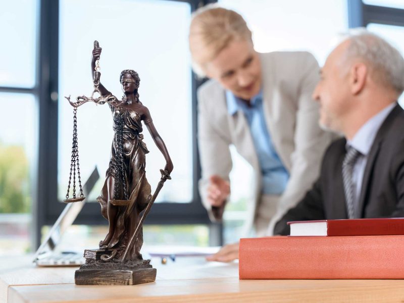 smiling-mature-lawyers-discussing-plans-at-workpla-VA9DE7E.jpg